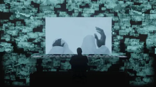 An Image of a silhouetted person sitting at a desk in a dark room, the person is looking at a glowy holographic monitor showing a security feed, the monitor is not 3d rather a 2d plane in 3d space. Behind this monitor are thousands of other similar monitors that are more transparent showing security feeds that are moving up from the reflective floor and disappearing at the top of the camera view. The floor is very reflective.